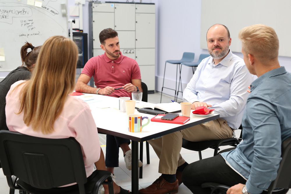 Group of professionals discussing ideas during a meeting at a table.