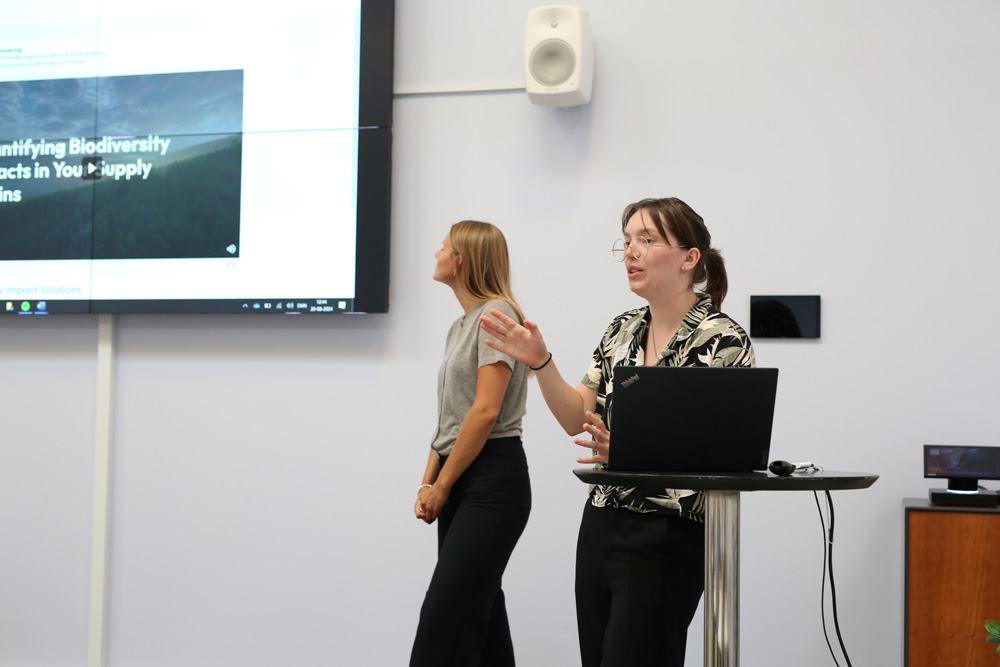 Two presenters discussing biodiversity impacts in a supply chain presentation.